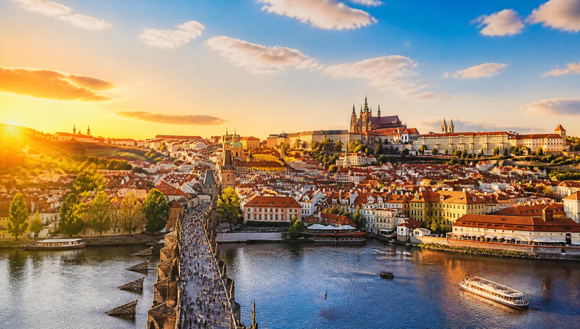 Praha v teplém večerním světle s Karlovým mostem a hradem